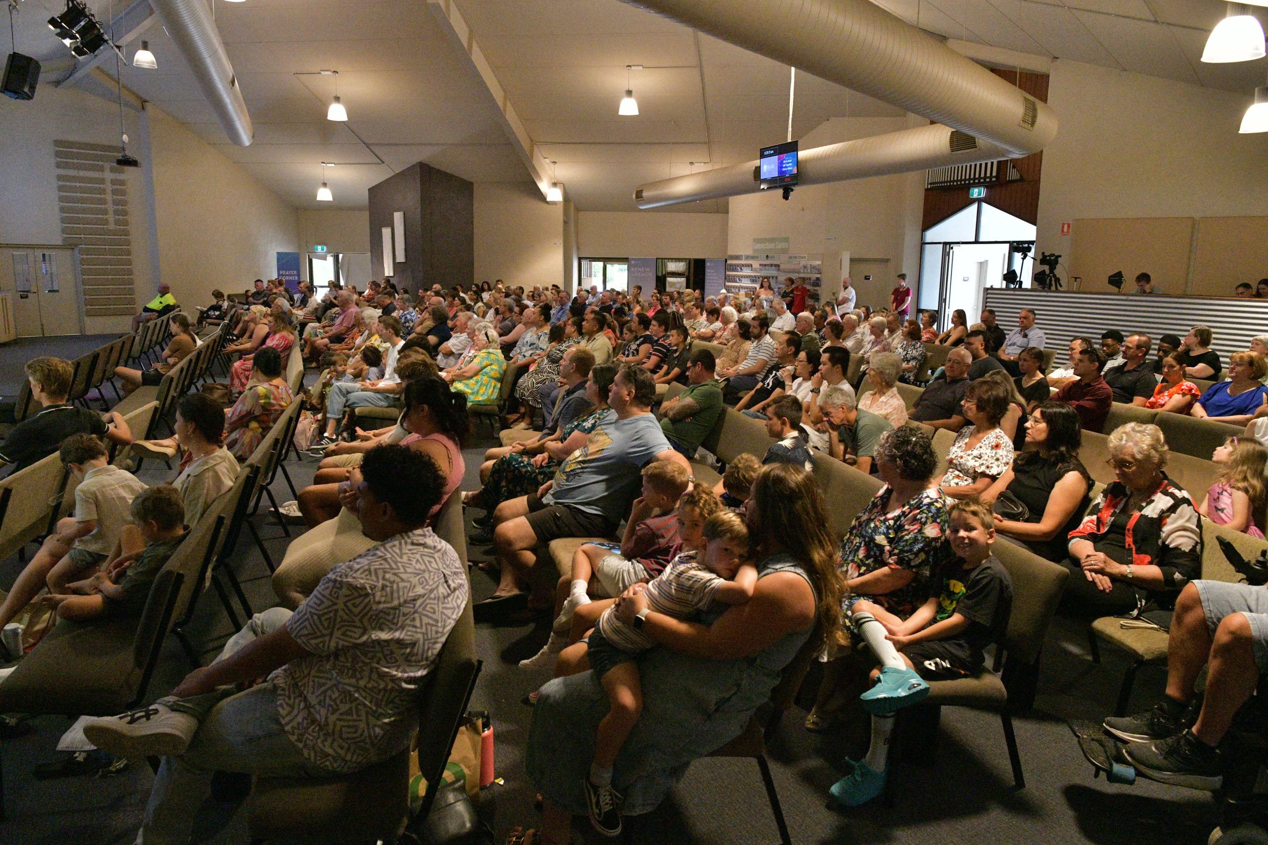 A large congregation fills the church, seated and listening attentively to a speaker at the front | Easter at Oasis Church